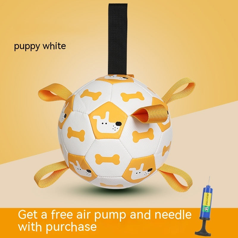 White dog toy ball with yellow accents and a black strap on a beige background