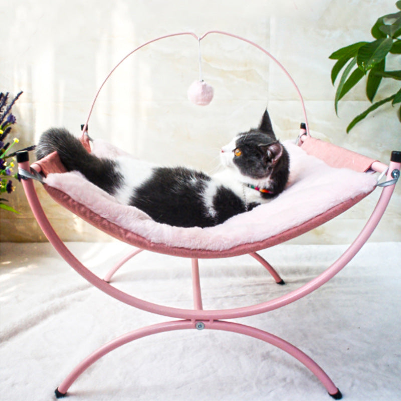 Cat lying on a pink pet hammock with a white background
