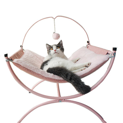 Cat lounging in a pink pet hammock with a white background
