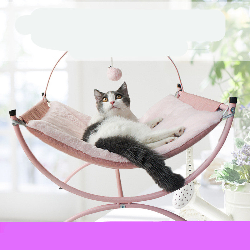 Cat lounging on a pink pet hammock with a blurred background