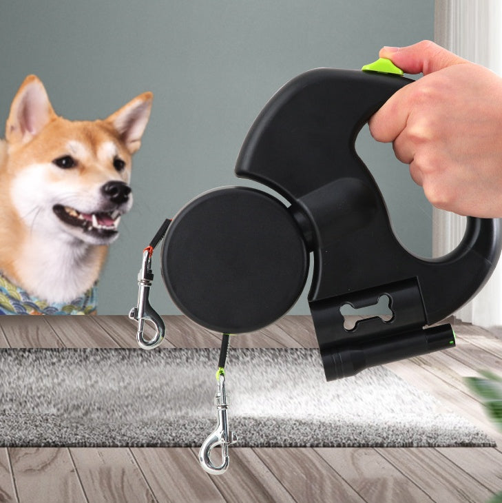 Retractable dog leash with a hand holding it, next to a dog on a wooden floor.