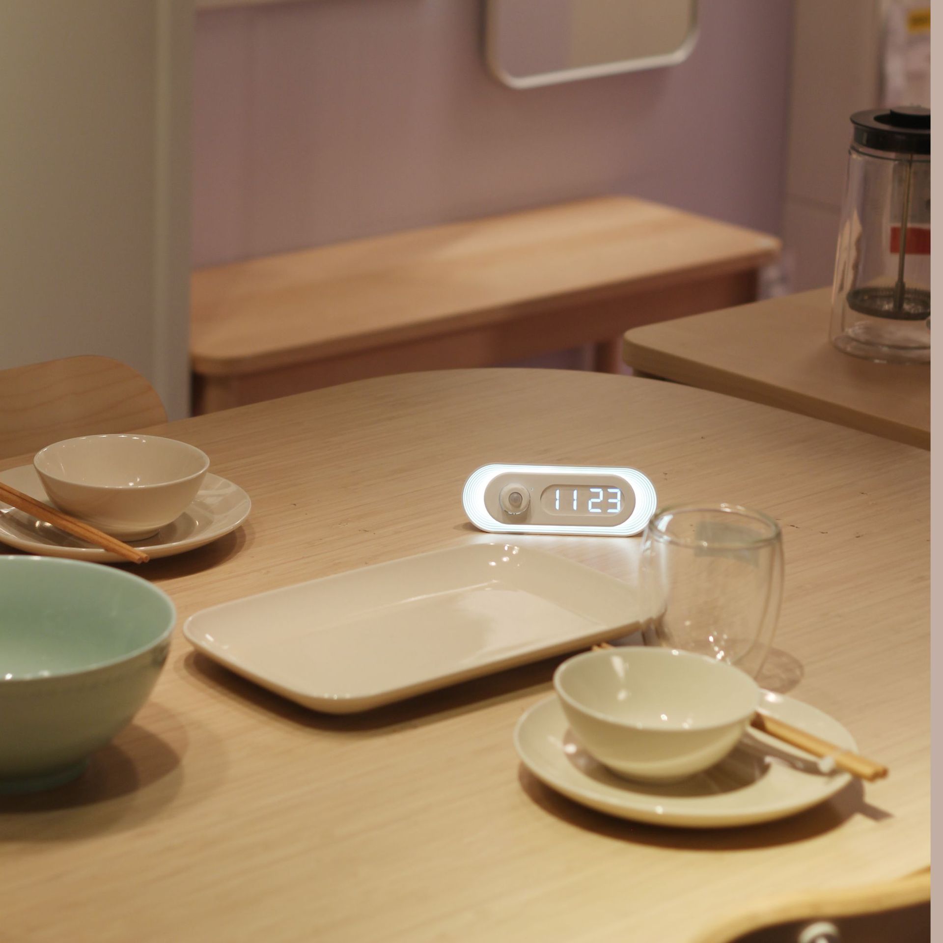 Dining table setup with bowls, a tray, and a digital clock displaying the time.