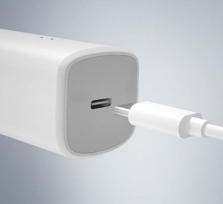 White USB-C charging cable being plugged into a white charging dock on a light gray background