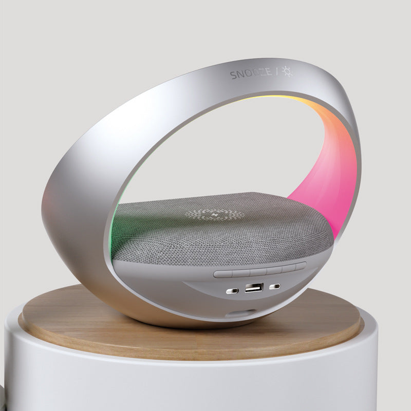 Modern speaker with colorful light display on a wooden stand against a light gray background