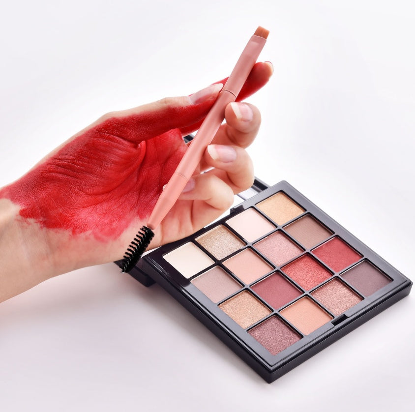 Makeup palette with a lip pencil and hand with red lipstick on a white background