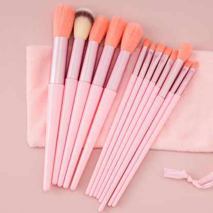 Set of pink makeup brushes with pink handles and bristles on a matching pink background.