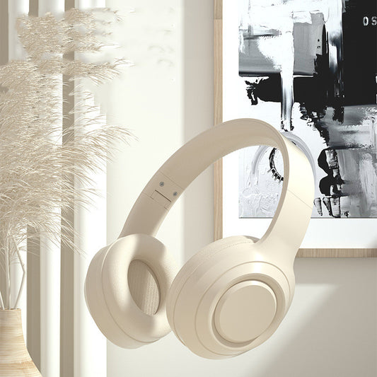 Noise Reduction Bluetooth Wireless Music Headset - 
Beige headphones on a surface with abstract art in the background