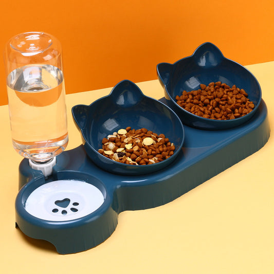 Pet feeding station with two bowls and a glass of water on an orange background