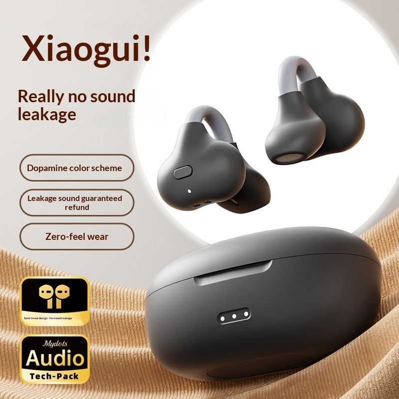 Ear Clip Bluetooth Wireless Headphones - Black wireless earbuds with charging case on a beige fabric background, featuring the brand 'Xiaogui'.