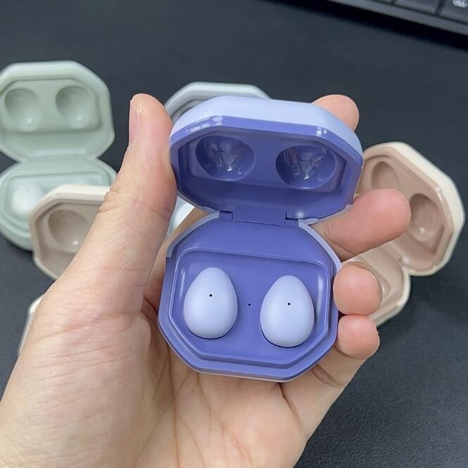 Ultra-Long Battery Bluetooth Sleep Headset - Hand holding a set of wireless earbuds in a purple case on a dark surface.