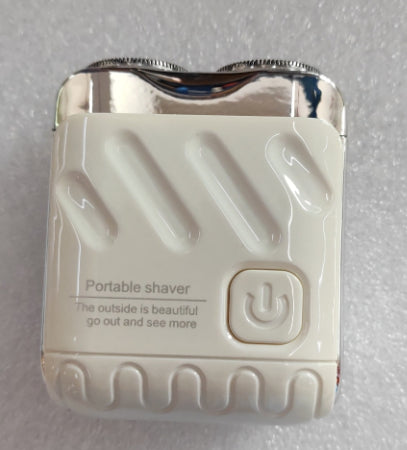 Portable shaver with power button on a gray background