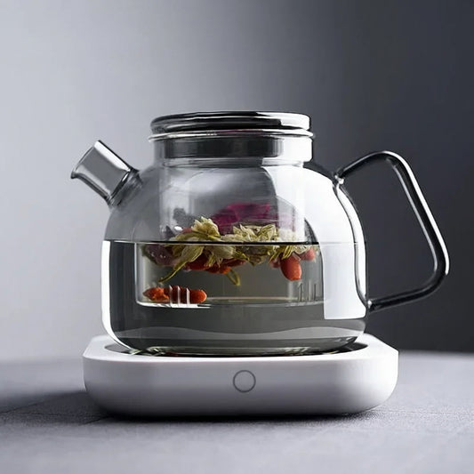 Glass teapot with a heating base on a gray background, featuring the Luckima brand.