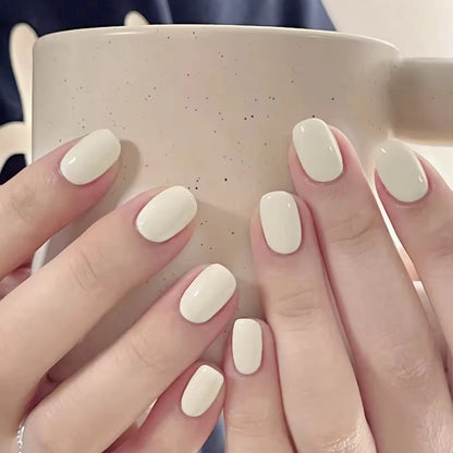 Close-up of hands with white nail polish holding a speckled mug.