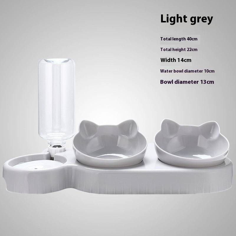 Light grey pet feeding station with water bottle and bowls on a light gray background