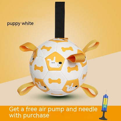 White dog toy ball with yellow accents and a black strap on a beige background